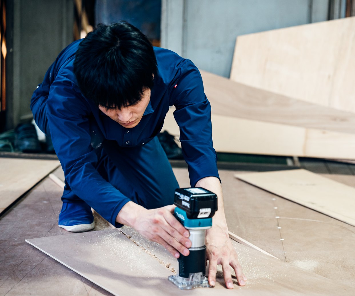 作業場で木材を加工する大工
